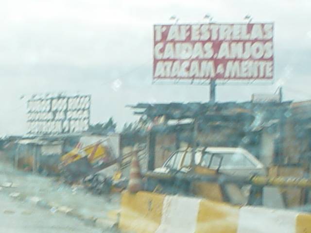 cartaz 1: '1o. AI: ESTRELAS CAÍDAS, ANJOS ATACAM A MENTE' / cartaz  2: 'JUROS DOS RICOS / DÍVIDA JÁ PAGA / DESTROEM O PAÍS'